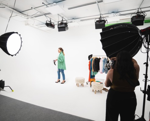 Woman on set in colorful clothing being photographed